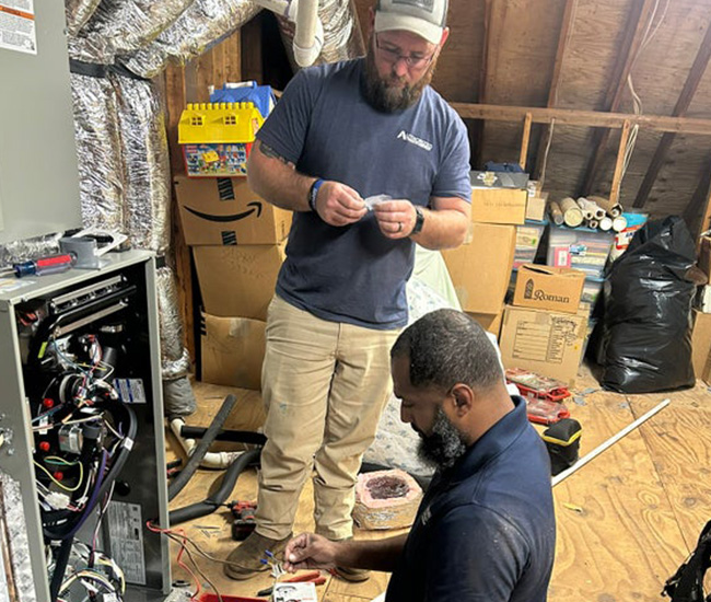 two techs working on heating unit